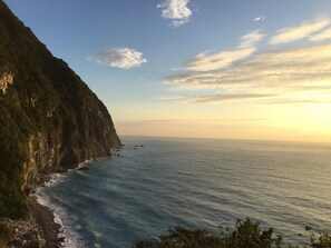 Un paysage côtier caractérisé par une falaise abrupte et une mer calme.