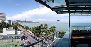 A high-rise hotel with a view of the sea, palm trees, and cityscape. - Serenotel Pattaya Beach Front (Pattaya)