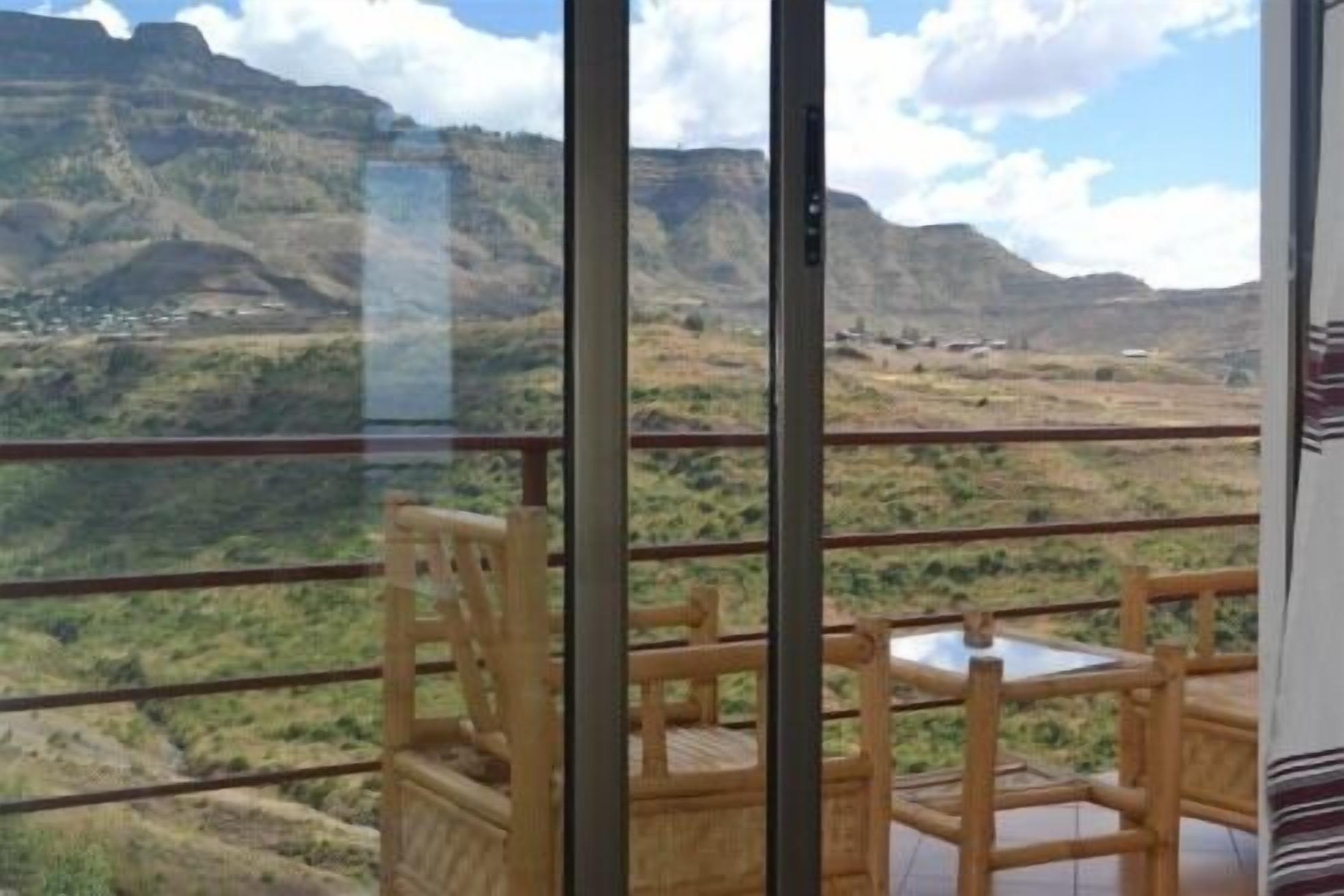 A balcony with a view of a mountainous landscape.
