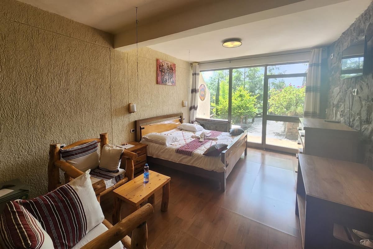 Une pièce comprenant un lit, une table en bois, une chaise et un bureau.