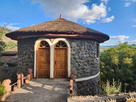Un edificio de piedra con dos puertas de madera y un techo de paja.