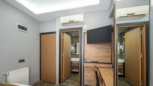 A modern bedroom with a skylight, built-in wardrobe, and a small sitting area. -  Vizyon Hotel - Old City (Istanbul)