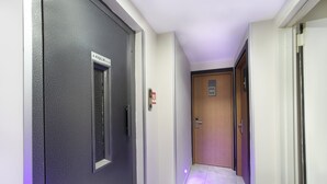 A hallway with a black door on the left, a wooden door in the center, and a white door on the right. -  Vizyon Hotel - Old City (Istanbul)