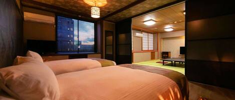Habitación de hotel con dos camas, un ventanal grande con persianas, decoración interior al estilo tradicional japonés y vistas a un jardín.