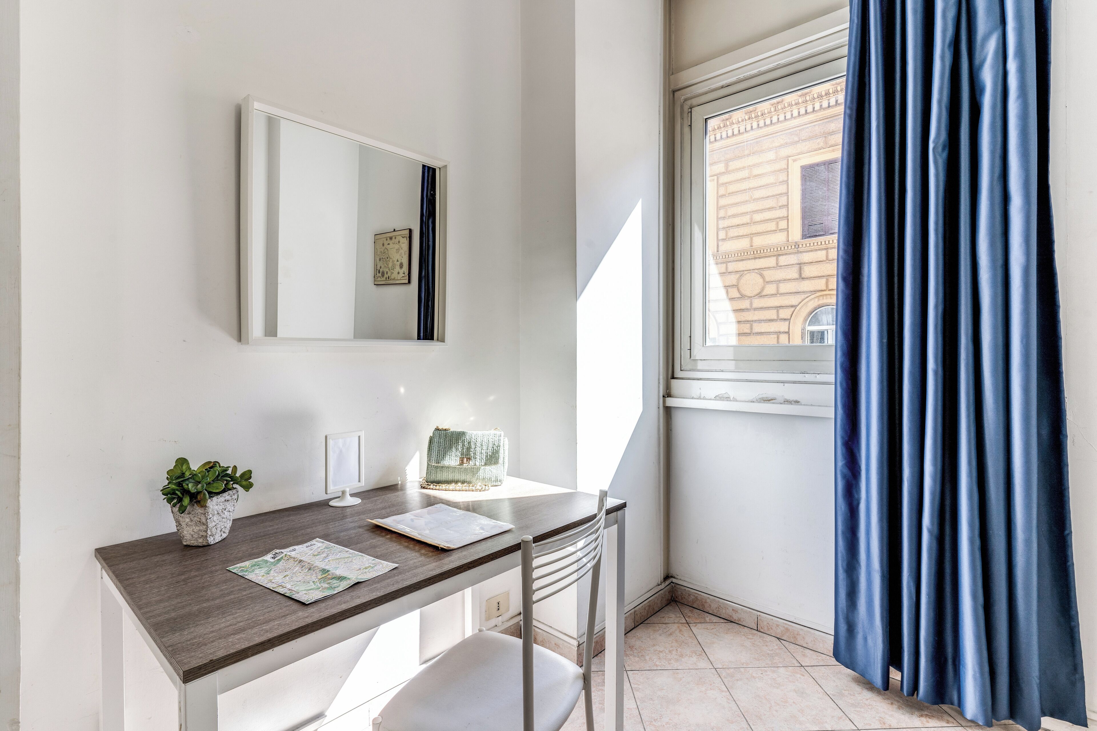 A small, modern room with a desk, chair, and a potted plant.