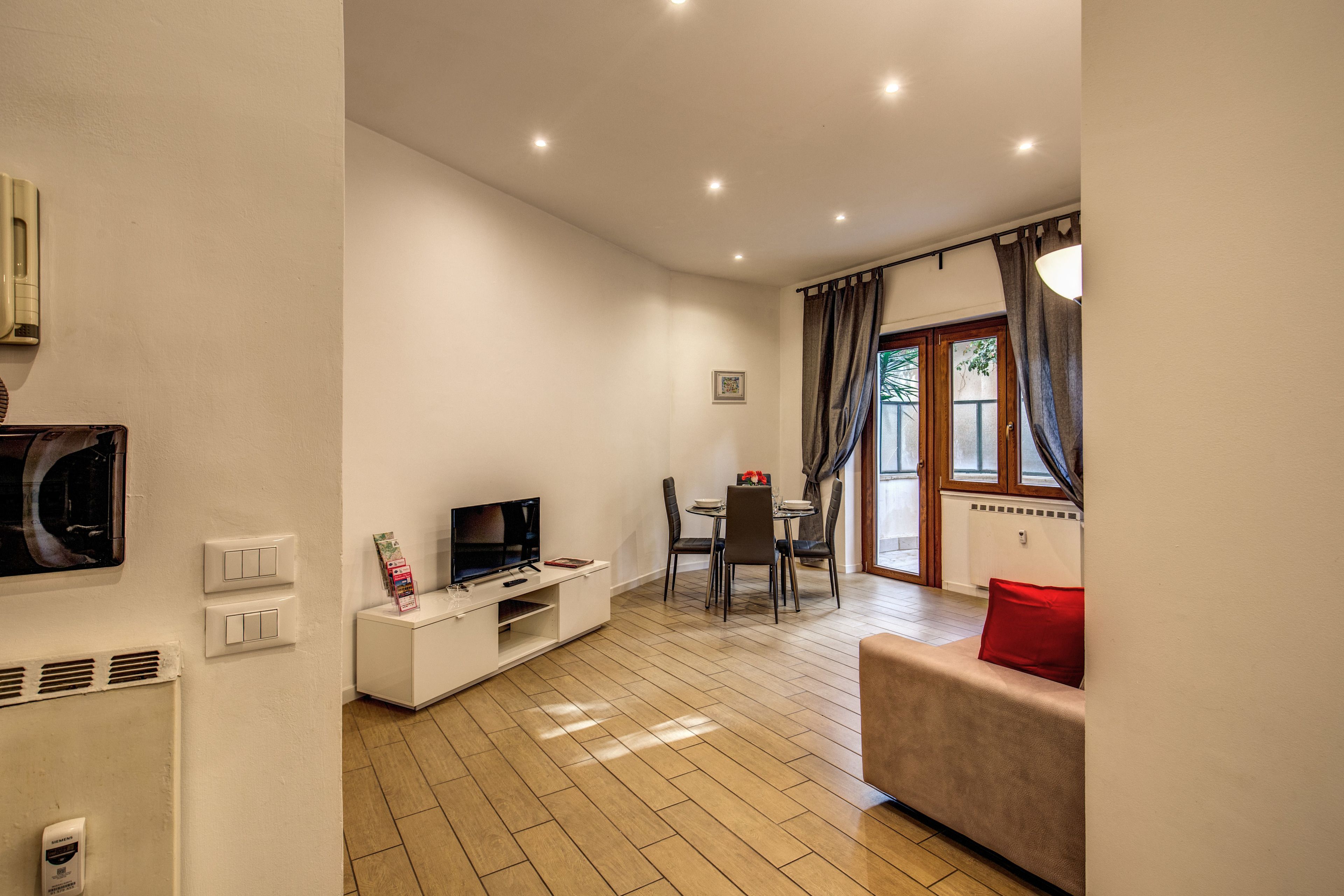 A modern living room with a TV, dining table, and sofa.
