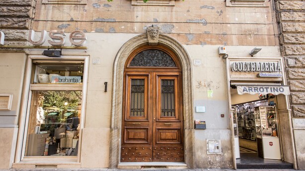 A historic building with a large wooden door, a sign for 'COLTELLERIA', and a 'brabantia' shop visible through the window. - M&L Apartment - case vacanze a Roma (Rome)