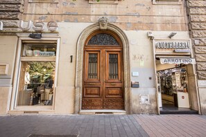 Un bâtiment historique doté d’une grande porte en bois, d’une enseigne indiquant « COLTELLERIA » et d’une boutique « Brabantia » visible à travers la vitrine.