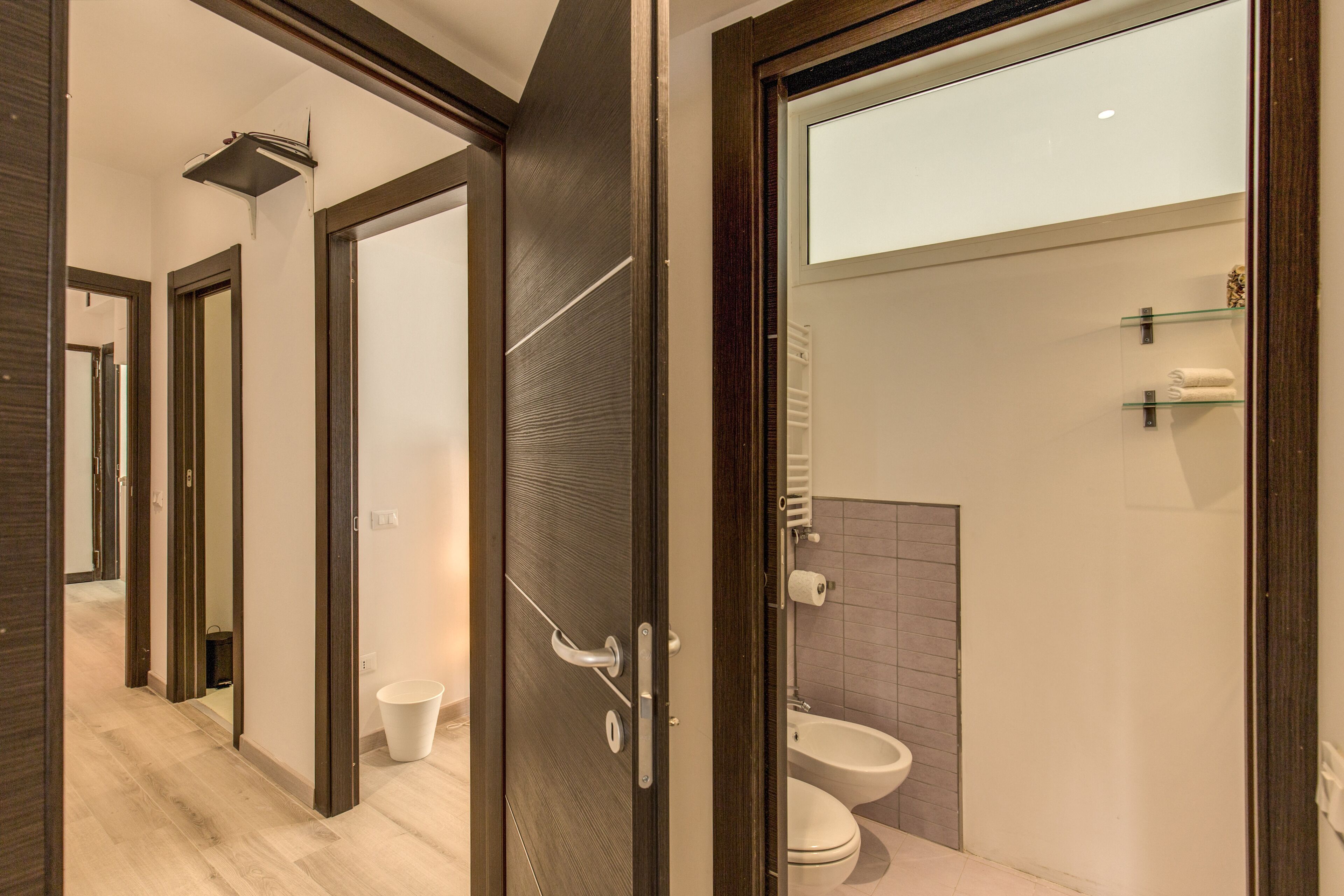 Ein modernes Badezimmer mit Toilette, Bidet und einer Glasablage.