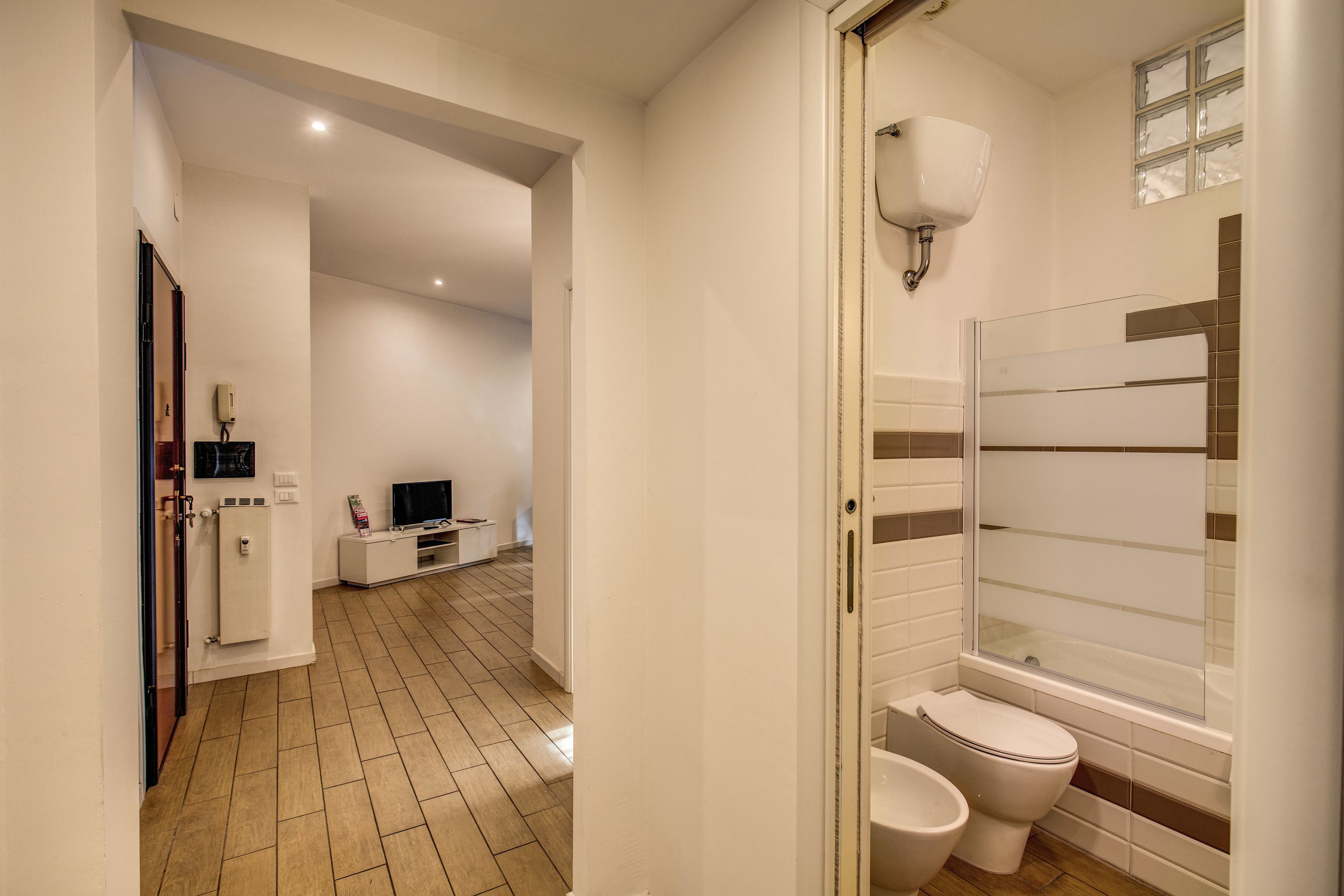 Une salle de bain moderne équipée de toilettes, d’un bidet et d’une douche à parois en verre.
