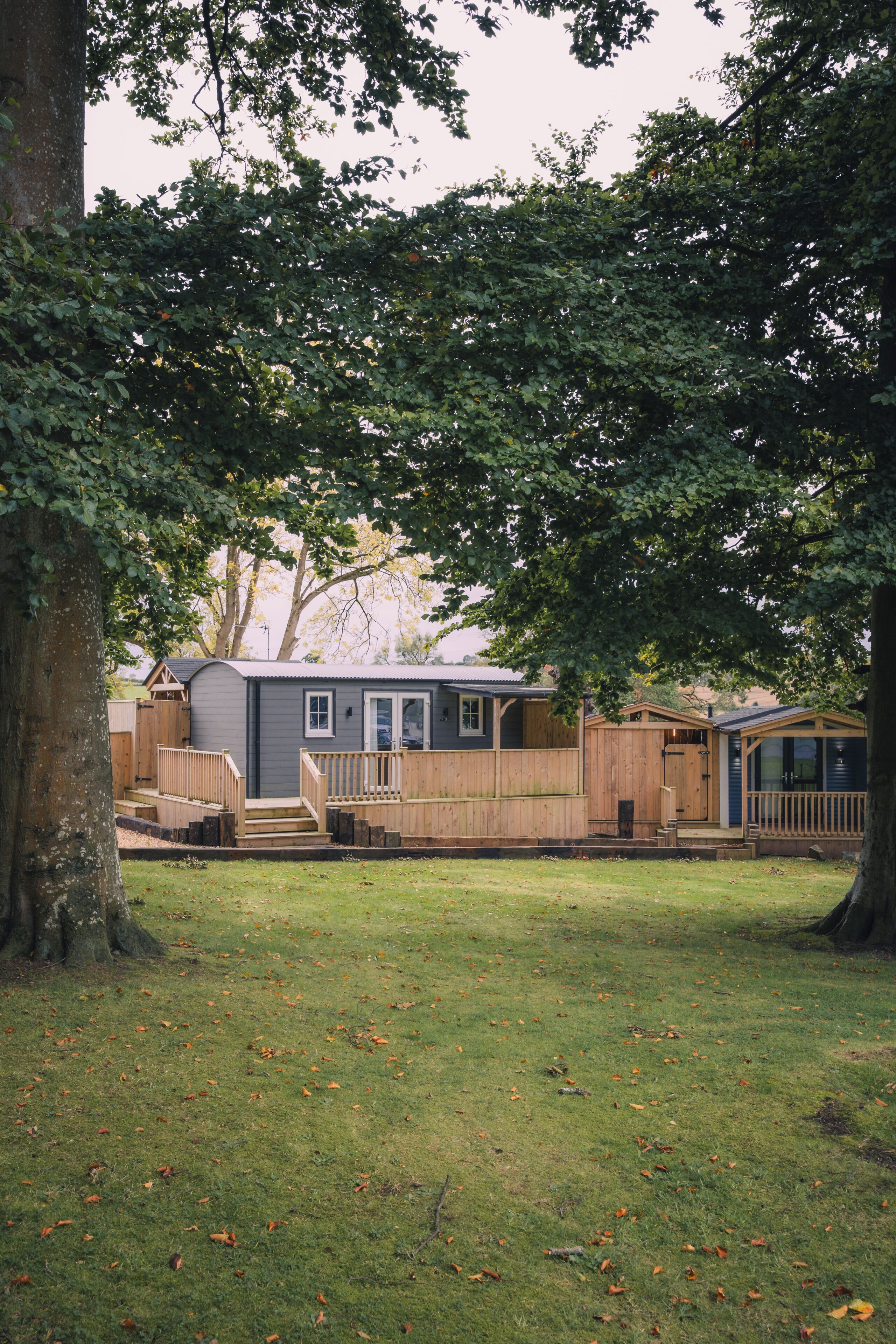 A small cabin with a wooden deck and a single-story structure.