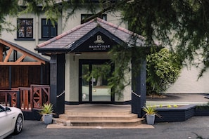 A building with a sign reading 'BANNVILLE HOTEL - BAR - VENUE' and a staircase leading to the entrance.