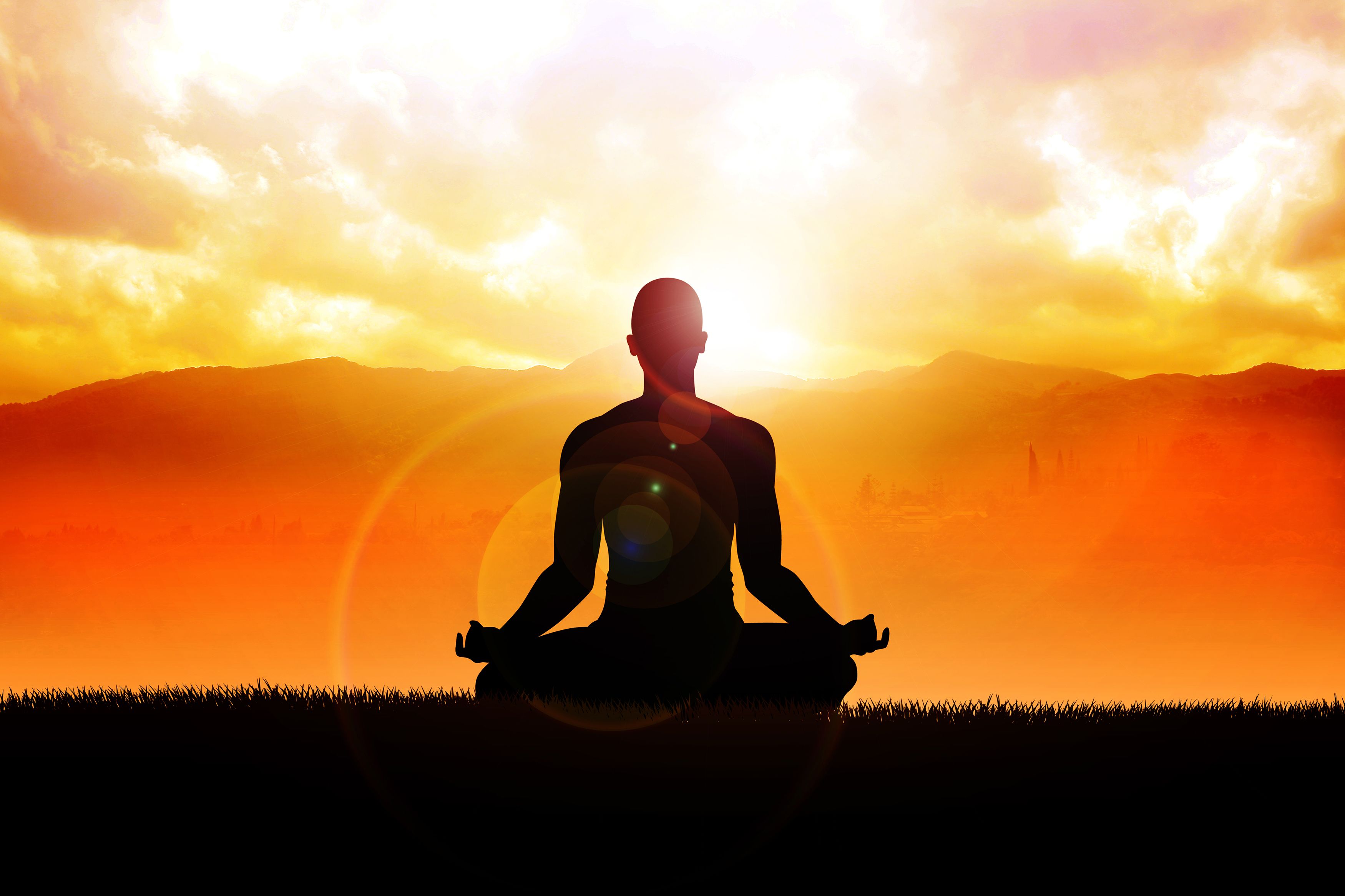 Silueta de una persona meditando con un atardecer de fondo.