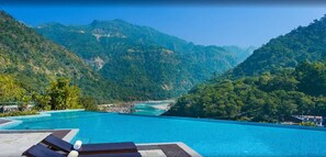 Une piscine à débordement offrant une vue sur un paysage montagneux.