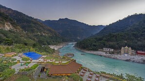 Een resort met een zwembad, buiten zitplaatsen en uitzicht op een rivier.