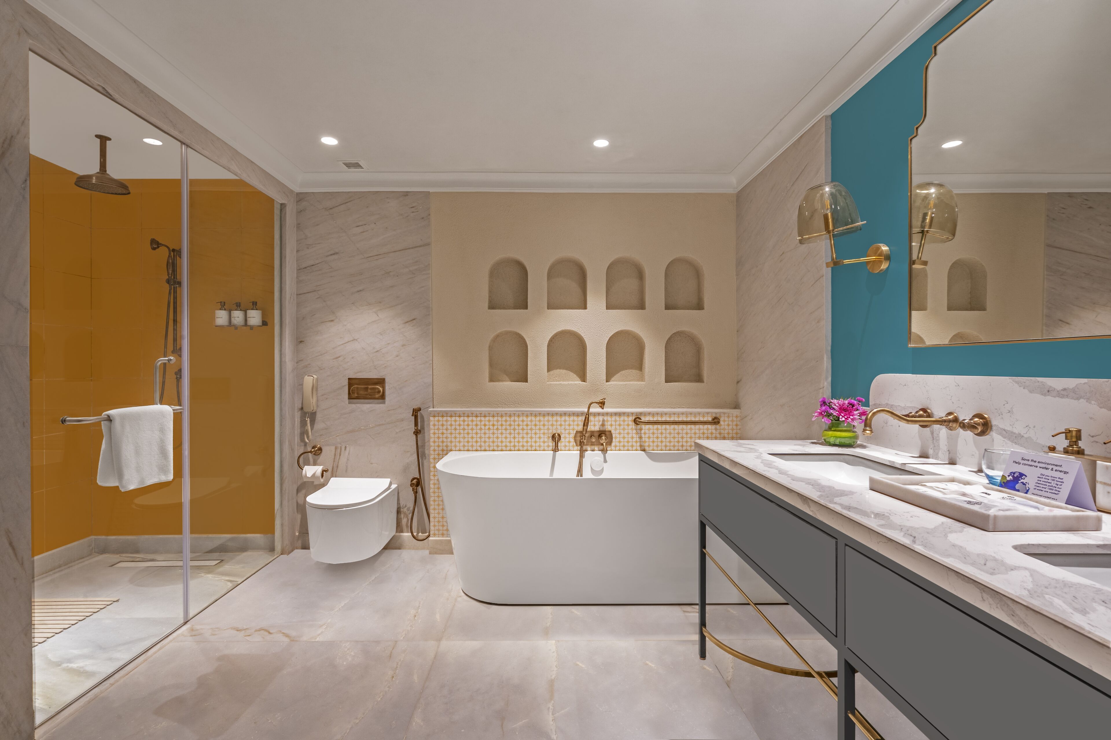 Un baño moderno con una bañera independiente, ducha con mampara de vidrio y tocador con lavamanos y espejo.