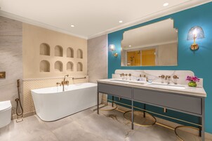 A modern bathroom with a freestanding bathtub, a double sink vanity, and a large mirror.