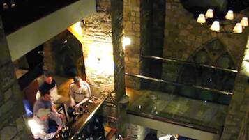 Un interior de piedra con una zona de bar y techos abovedados.