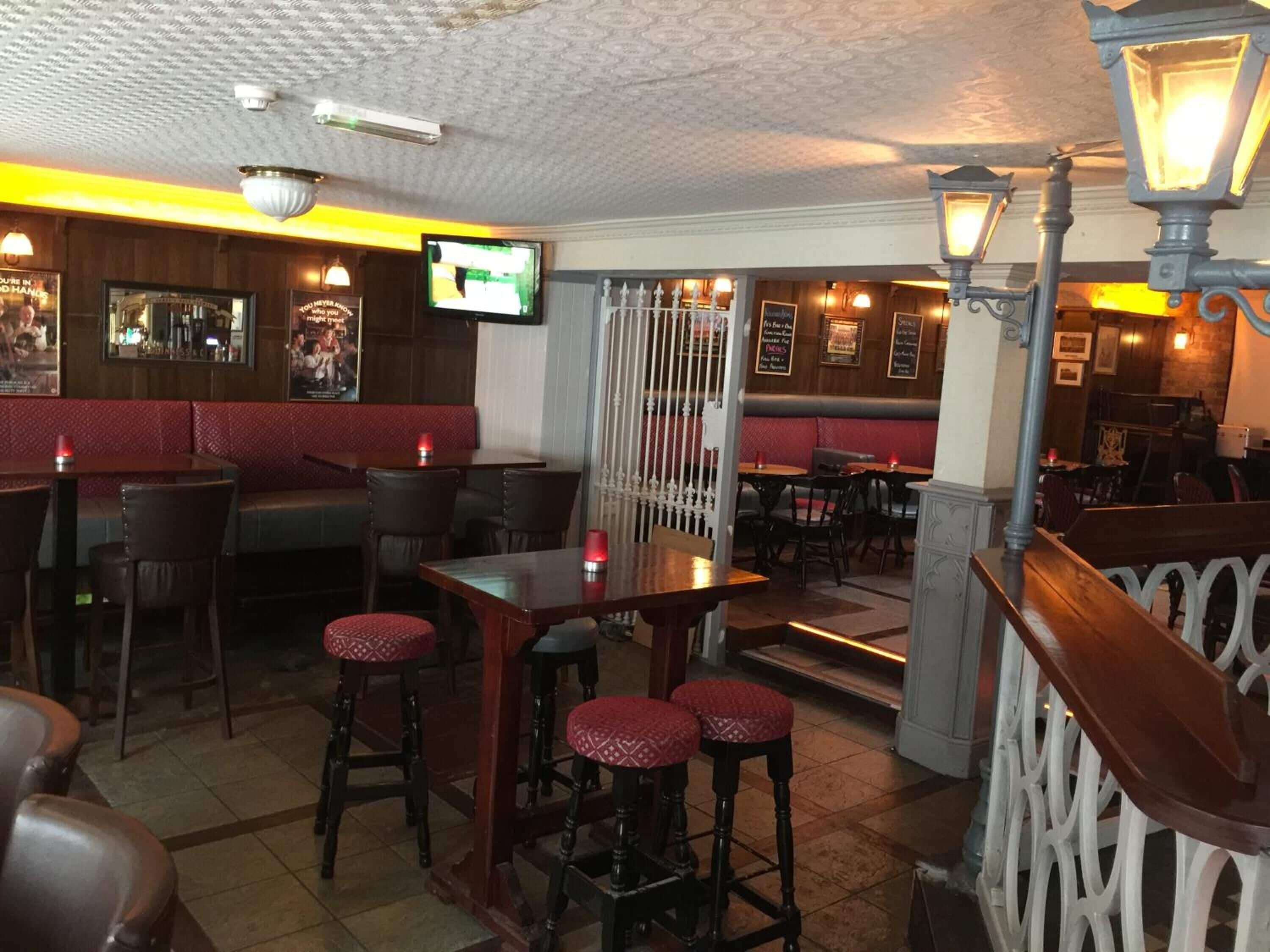 A restaurant interior with booths, high tables, and bar stools.