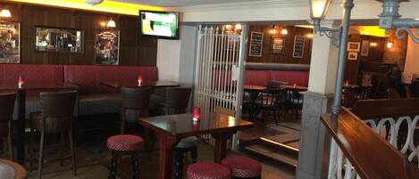 A restaurant interior with booths, high tables, and bar stools.