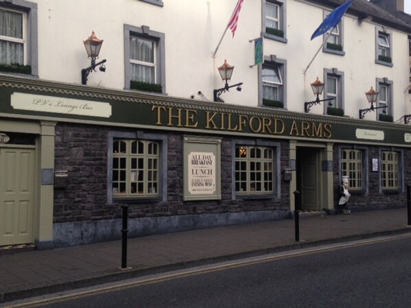 The Kilford Arms, a pub with a stone facade, multiple windows, and outdoor seating.