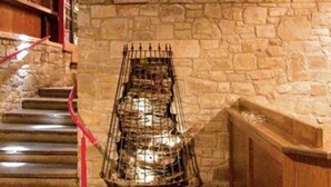 A staircase with stone walls and a metal railing, leading to a higher level.