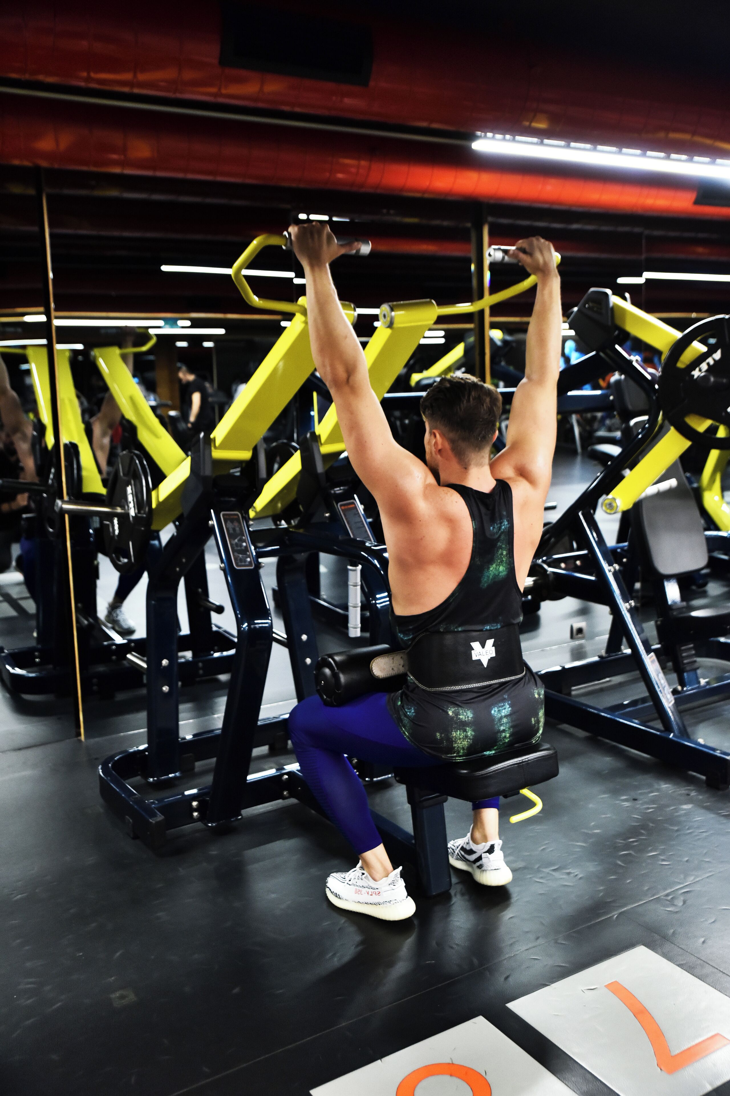Ein Fitnessstudio mit unterschiedlicher Trainingsausstattung, darunter eine Hantelbank und ein Squat-Gestell.