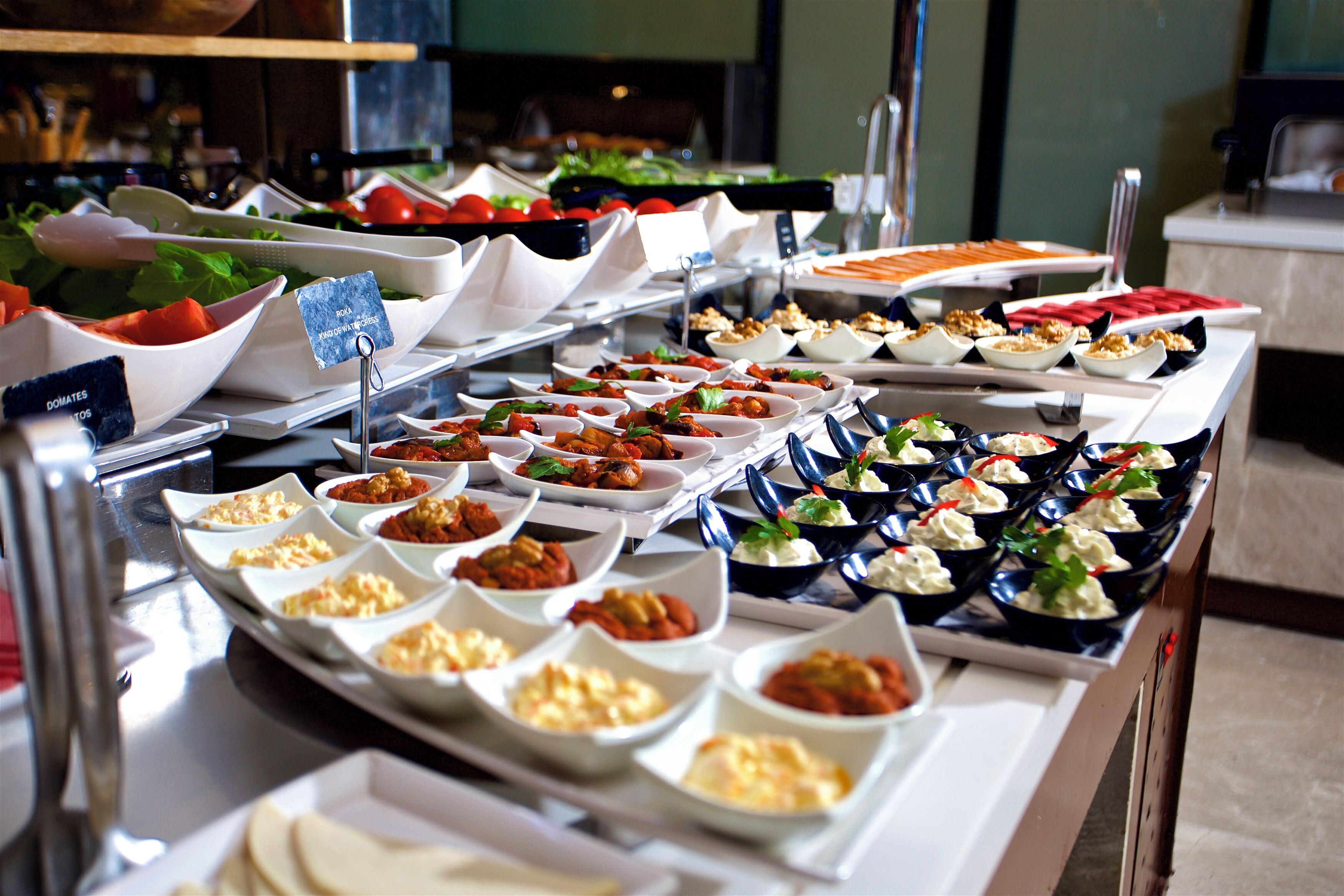 En buffet med forskellige retter anrettet i skåle og på tallerkener.
