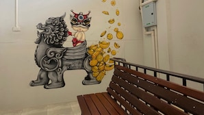 Une fresque murale représentant un lion et un enfant, un banc et un coffret de raccordement.
