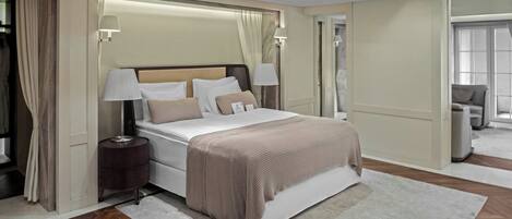 Habitación de hotel moderna con una cama grande, lámparas de noche, mesita de noche y vista al pasillo.