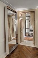 Um banheiro moderno com um espelho grande, piso de madeira e toucador com pia e porta-toalhas.