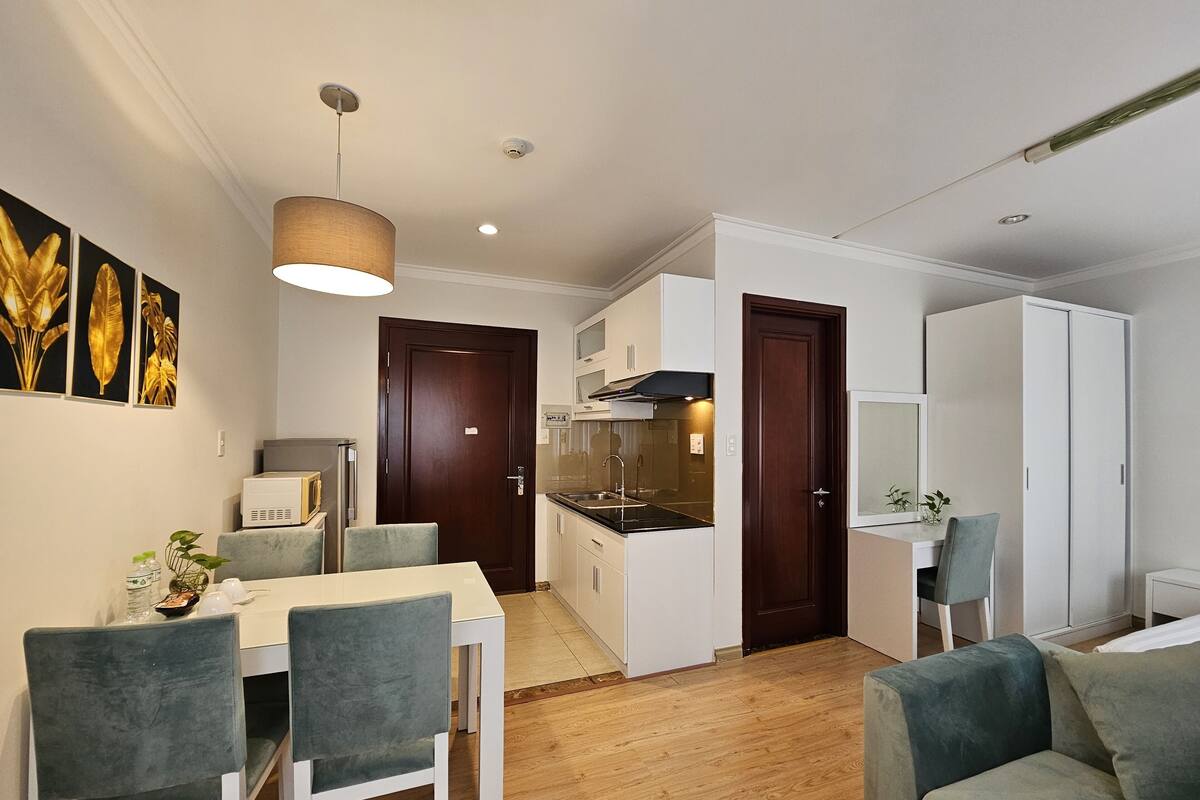 Un espace de vie compact comprenant un coin repas, une kitchenette et un coin salon.