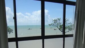 Une chambre avec une grande fenêtre donnant sur une plage.