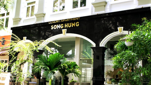 A luxury apartment building named SONG HUNG with a black facade and arched entrance. - Song Hung Hotel & Serviced Apartments (Ho Chi Minh City)