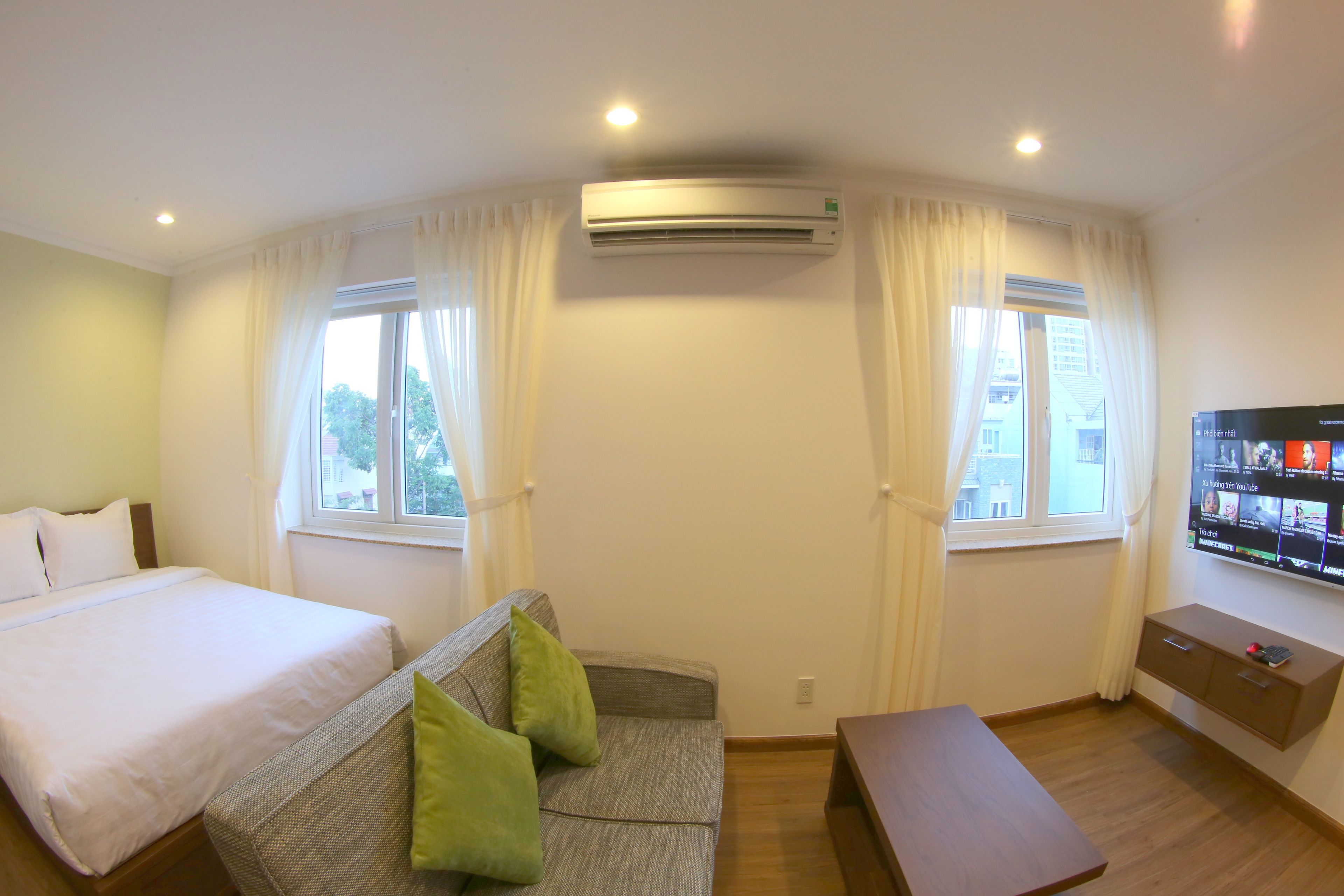 Une chambre d’hôtel équipée d’un lit, d’un canapé, d’une télévision et d’un appareil de climatisation.