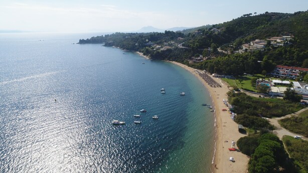 Una zona costera con playa, barcos y edificios.