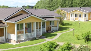 A yellow cottage-style building with a porch and a small garden area.