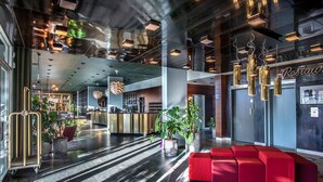 Eine moderne Lobby mit Empfangsschalter, Sitzgelegenheiten und Topfpflanzen.