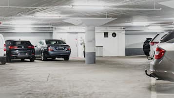 Un aparcamiento con varios coches estacionados, una zona de recepción y un pilar.