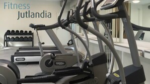 Ein Fitnessstudio mit Laufbändern, Rudergerät und Kurzhanteln.