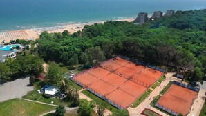 An aerial view of a coastal area with a beach, a tennis court, and a swimming pool. - Hotel Boryana (Kranevo)