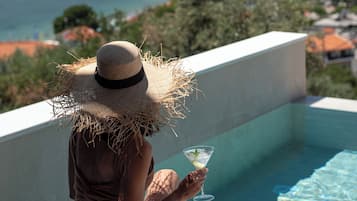 Una piscina al aire libre de temporada, sombrillas, tumbonas