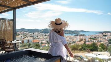 Une personne se détend dans un bain à remous avec vue sur une ville côtière.