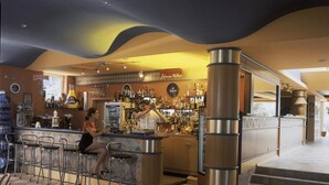 A bar area with stools, a counter, and a variety of bottles and glasses. - Hotel Kaliopa (Albena)