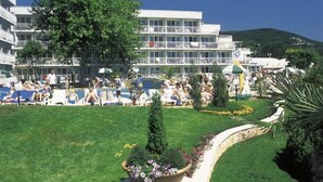A hotel with a pool area, lounge chairs, and a large building with balconies. - Hotel Kaliopa (Albena)