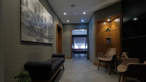 A modern interior with a sofa, chairs, a small table, and a painting on the wall. - Nordstern Hotel Galata (Istanbul)
