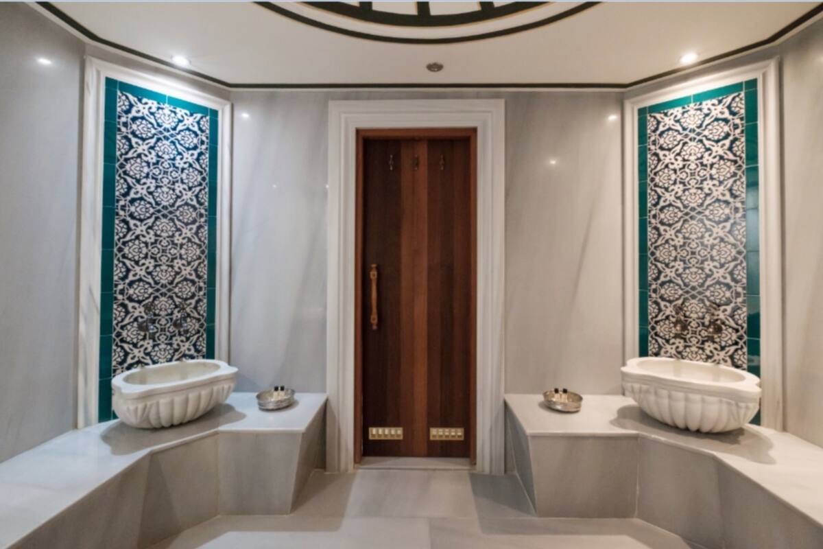 Un baño con dos lavamanos, una puerta de madera y azulejos decorativos.