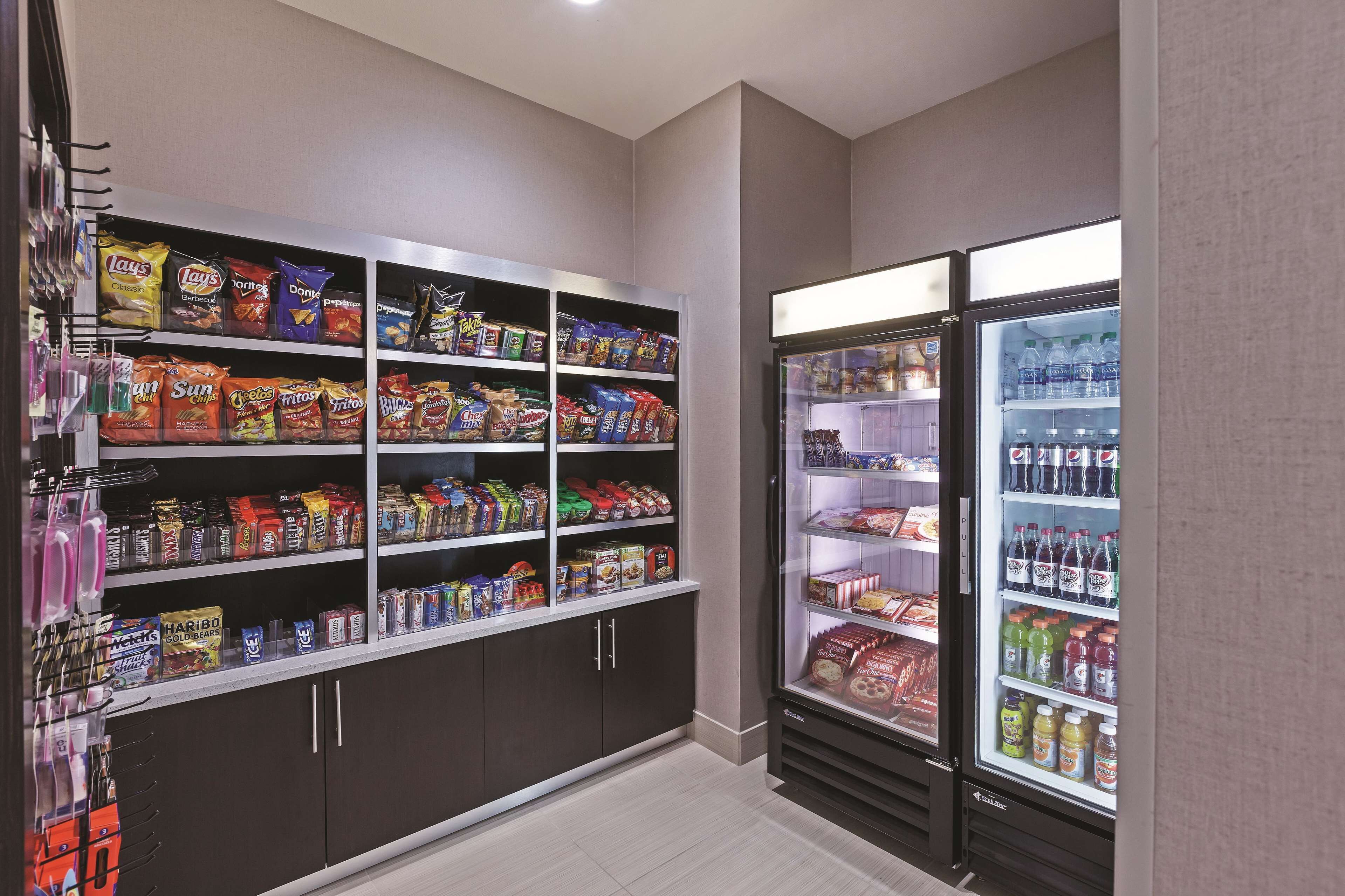A snack and beverage vending area with multiple shelves of chips, snacks, and bottled drinks.