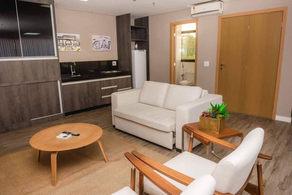 A modern living room with a sofa, a coffee table, and a small wooden side table with a plant.