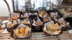 Um buffet com diversos pães e doces em cestos de vime.